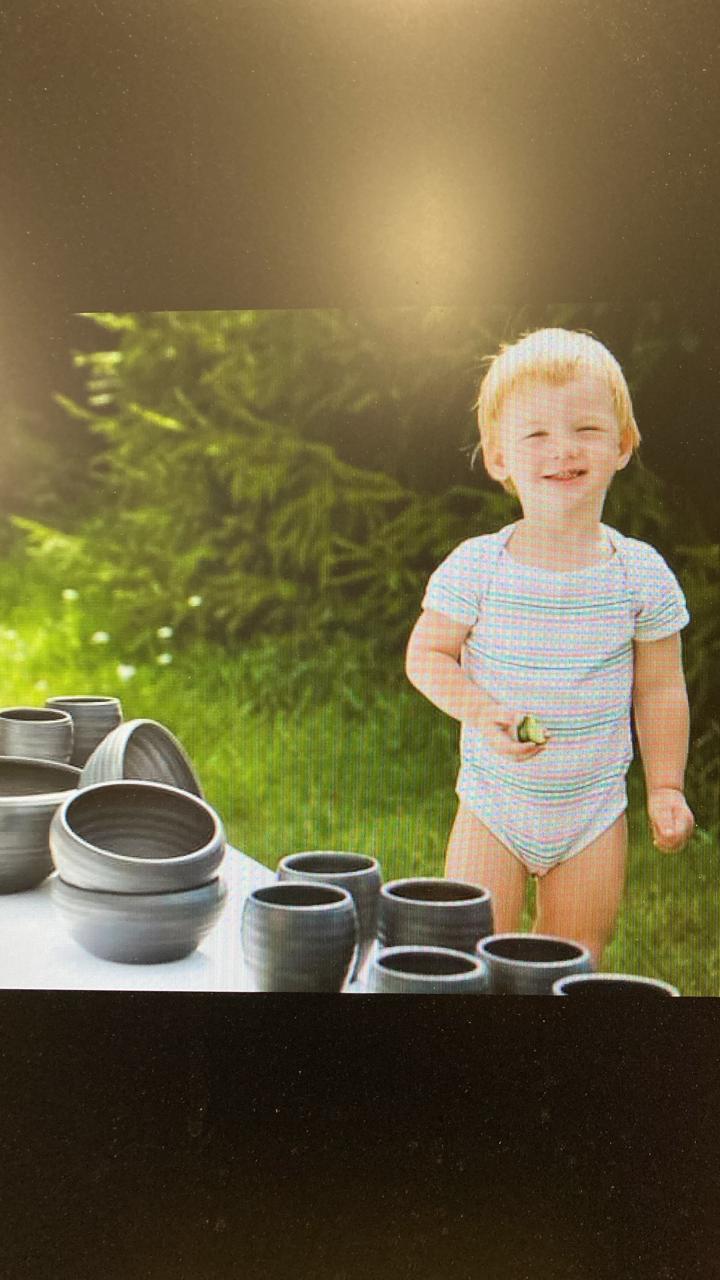 Matiass Preiss as a child outside with ceramic work in summer